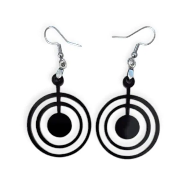 Close-up of black Laser Cut Acrylic Bullseye Earrings featuring three concentric circles with a central dot, suspended from silvertone surgical steel ear wires against a white background.