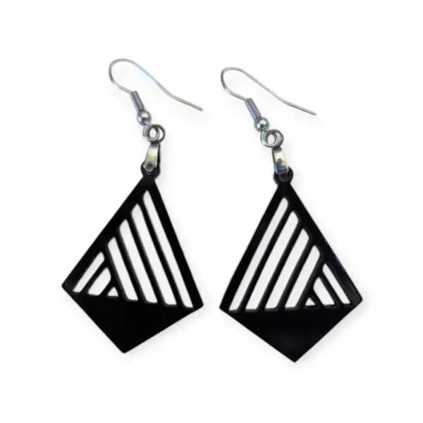 Black Laser Cut Acrylic Slash Earrings with asymmetrical linear cutouts, featuring a bold geometric design, hanging from silver hooks against a white background.