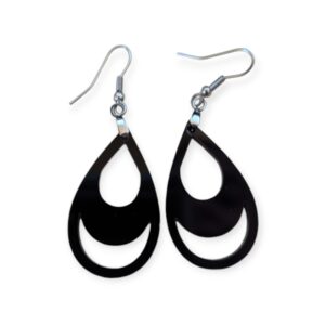 Black teardrop-shaped acrylic earrings with crescent moon cutouts, hanging from silver-tone hooks against a white background. Laser Cut Acrylic Crescent Moon Earrings.