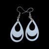 White teardrop-shaped earrings with crescent moon cut-outs, featuring a sleek lunar design inside a tear silhouette, hanging from silver hooks against a black background.