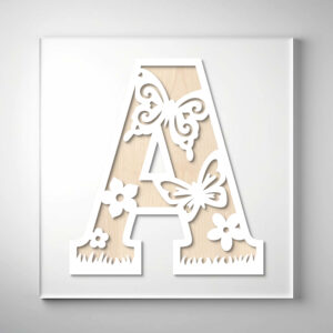 Laser-cut wooden letter "A" featuring butterflies, flowers, and grass cutout designs over a natural wood grain background.