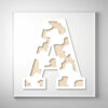 A cow print wooden letter "A" with a modern cutout design, layered over a light wood background.