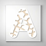 Laser-cut giraffe print wooden letter "A" with intricate cutout patterns over a light wood grain background.