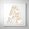 Laser-cut wooden letter "A" featuring heart-shaped cutouts over a natural wood grain background.